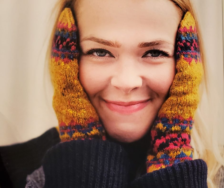 Gold mittens with colorwork at cuffs & tops, modeled by a woman